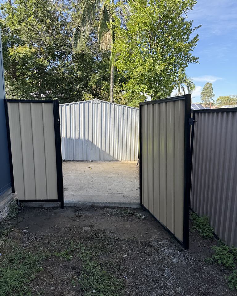 Colorbond fence with a double gate opening onto a driveway