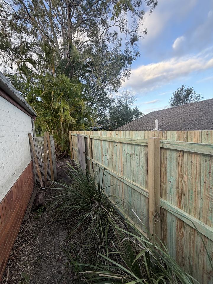 Timber screen fence beside a house with planting in front of it