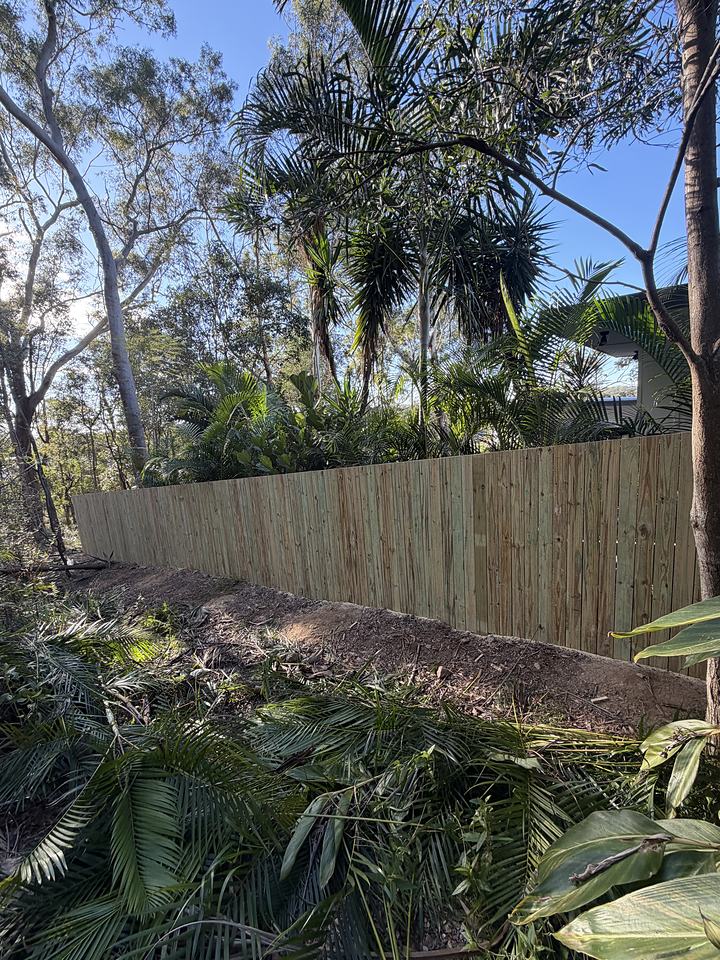 Timber paling fence with the ground in front of it cleared and levelled