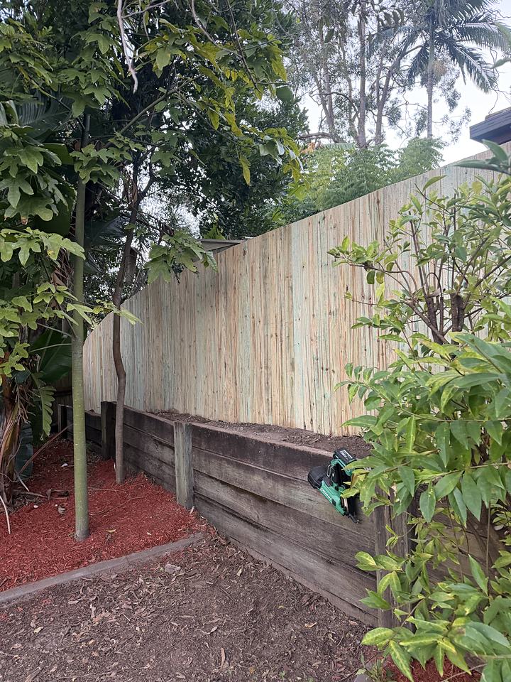 Timber paling fence built level on top of a sleeper retaining wall