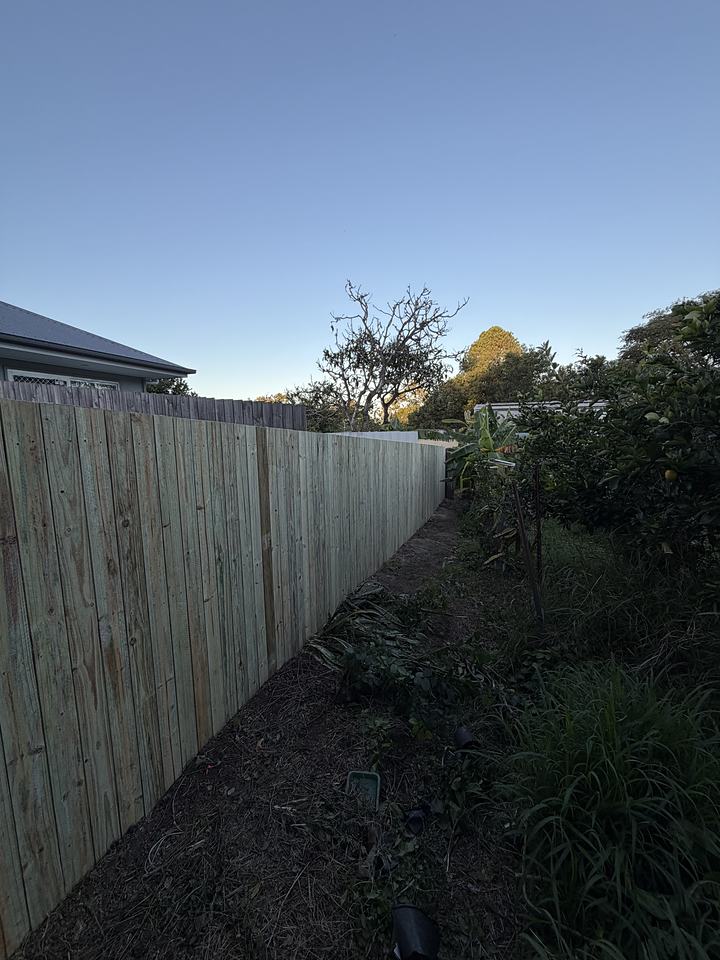 Long straight timber paling fence along a rear boundary