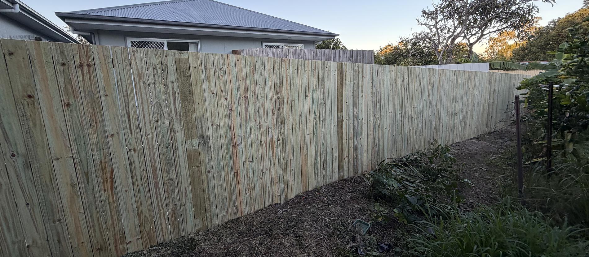 A finished timber paling fence running the full length of a back boundary